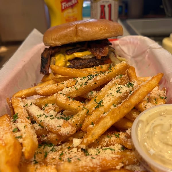A double cheeseburger with bacon and onions, served with parmesan fries and a side of dipping sauce.